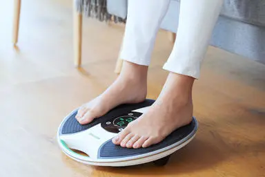 Close up of womans feet on a medic device