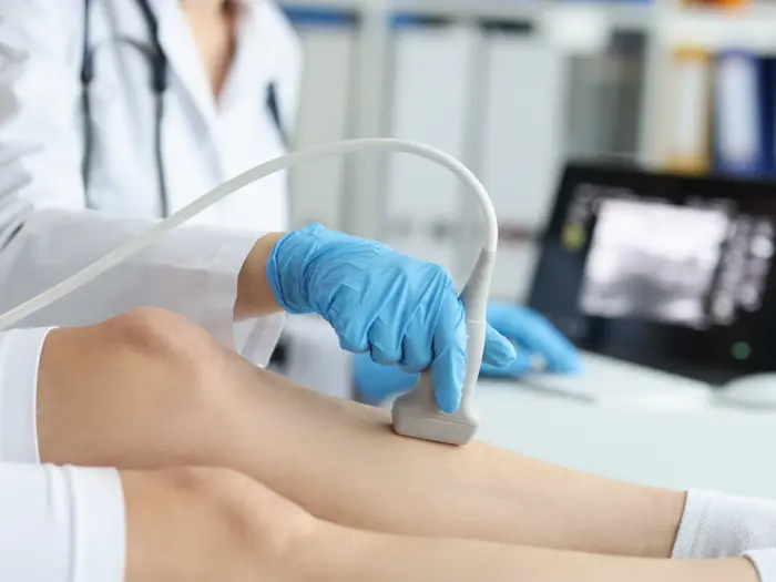 Doctor using ultrasound on leg to test circulation