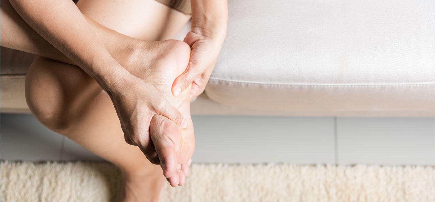 Image d'une femme se frottant la plante du pied 